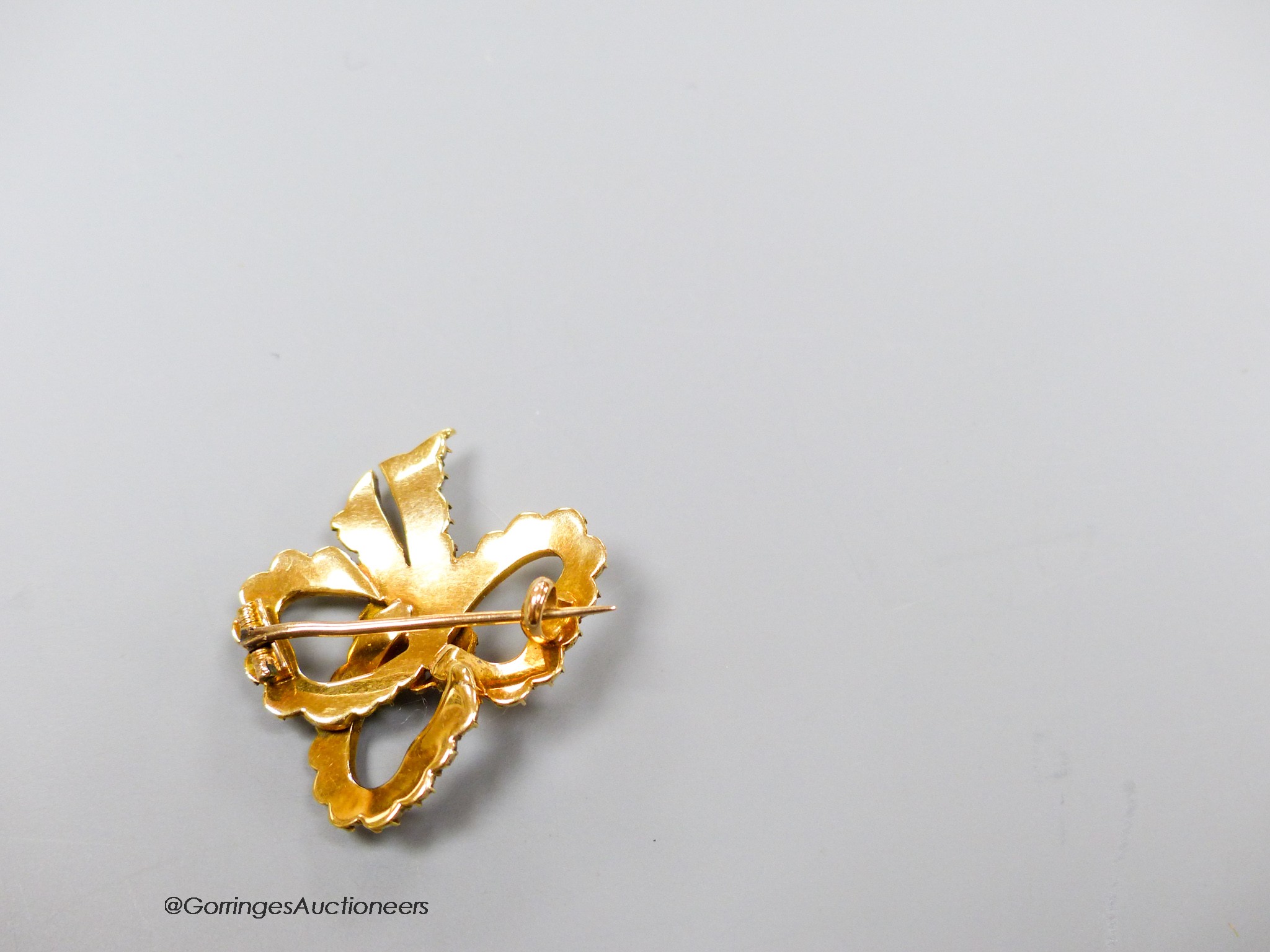 A yellow metal and split pearl set ribbon bow brooch, 30mm, gross weight 6.1 grams.